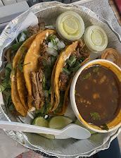 Birria tacos with a cup of consomé for dipping