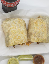 Burrito packed with meat and melted cheese, cut in half
